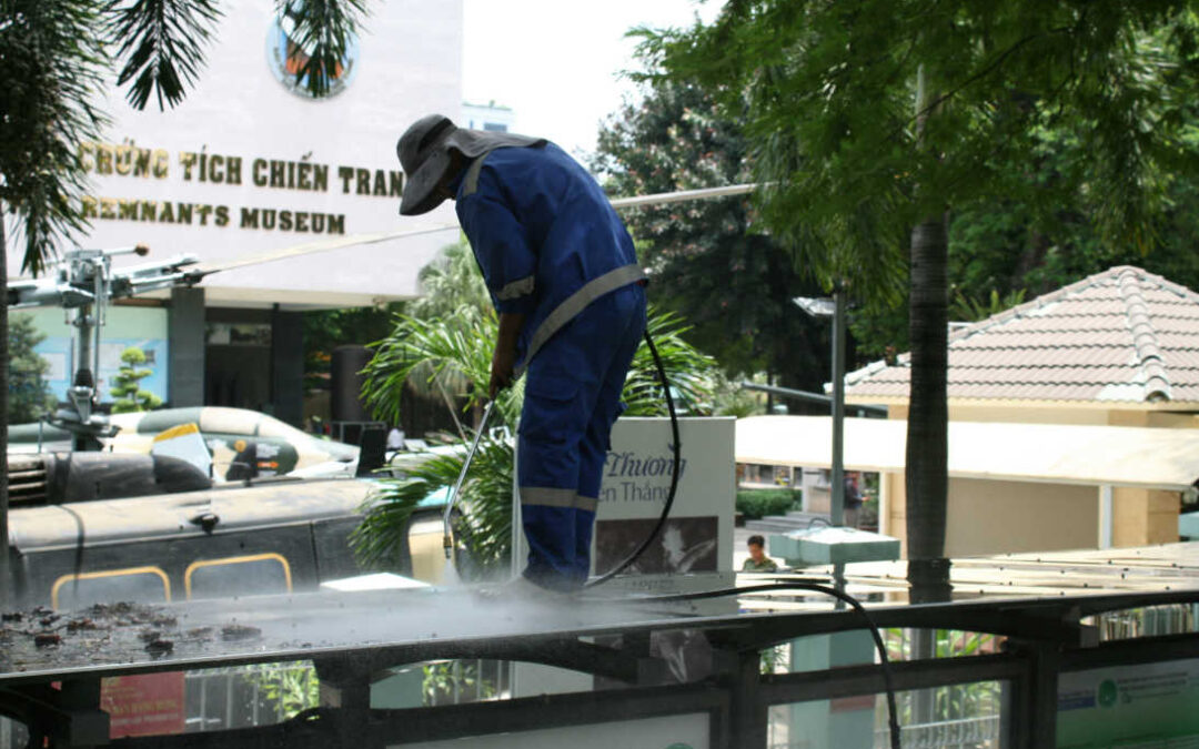 heavy build-up cleaning, worker pressure washing an outdoor canopy