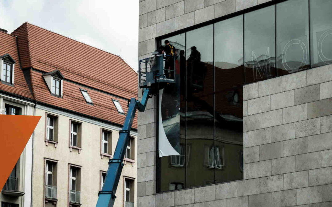 High-level dusting, workers on a boom lift cleaning exterior windows