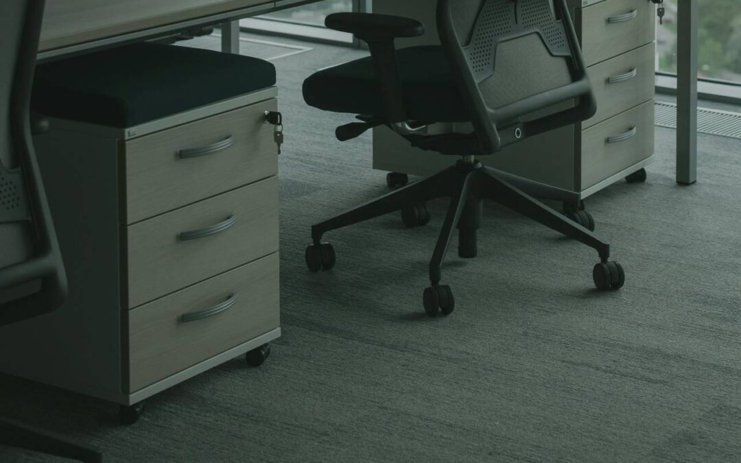 Office carpet cleaning beneath desks and rolling chairs in a modern workspace